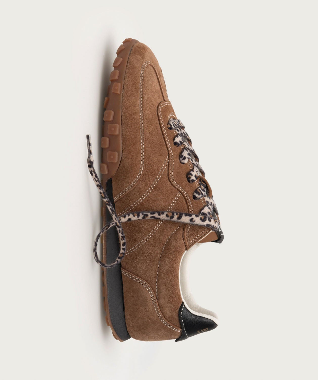 Brown shoe with leopard print trim on a light gray background