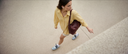 Woman walking on a sidewalk with a brown bag